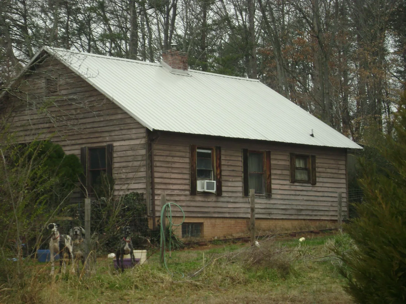 White metal roof on an old wood sided farmhouse, from a Metal Roof Installation job in Rockwell